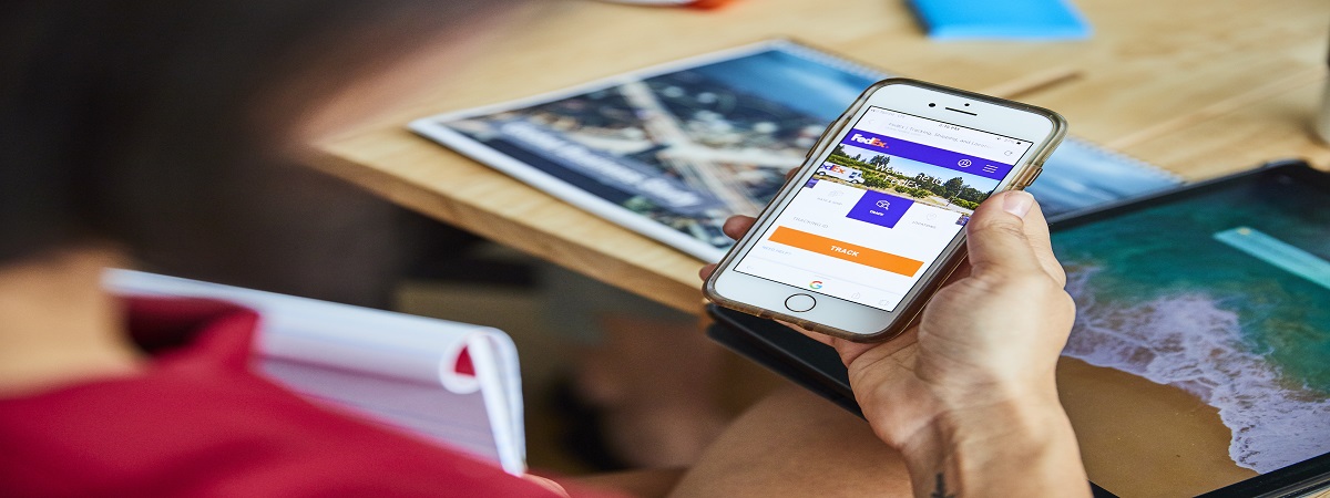 Person holding a cellphone examining the FedEx site
