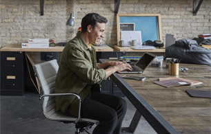 Man using laptop at a office table