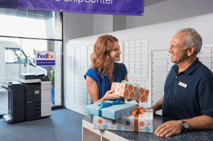 Woman smiling holding a FedEx box Woman smiling holding a FedEx box