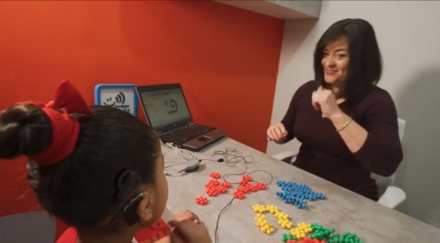 A woman and young girl sitting at a desk