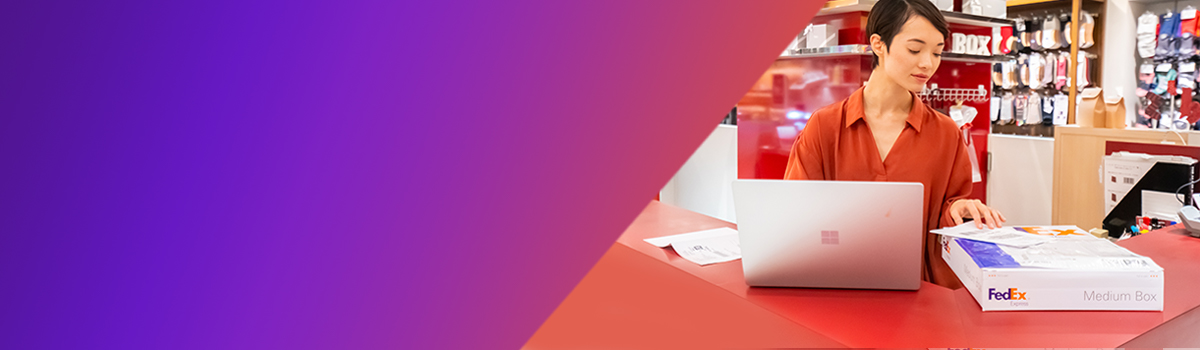 A shopkeeper printing labels for a FedEx box