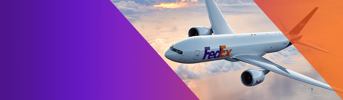 FedEx plane flying over water and clouds