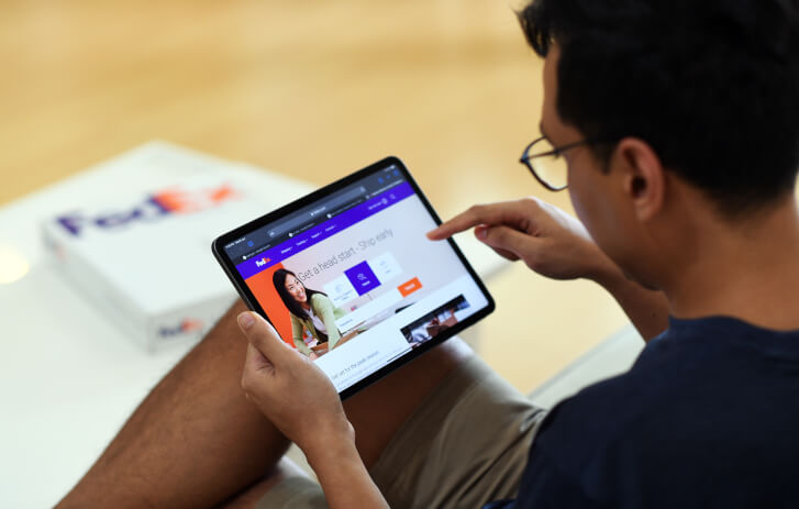 a man browsing the FedEx website on his tablet