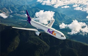 FedEx plane flying above clouds