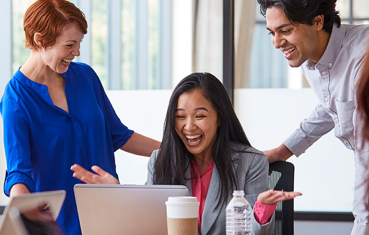 team smiling at a computer