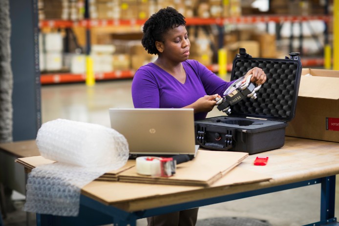 Woman packaging an item in a warehouse