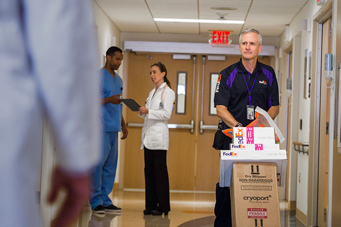 FedEx courier walking down a hall in a hospital