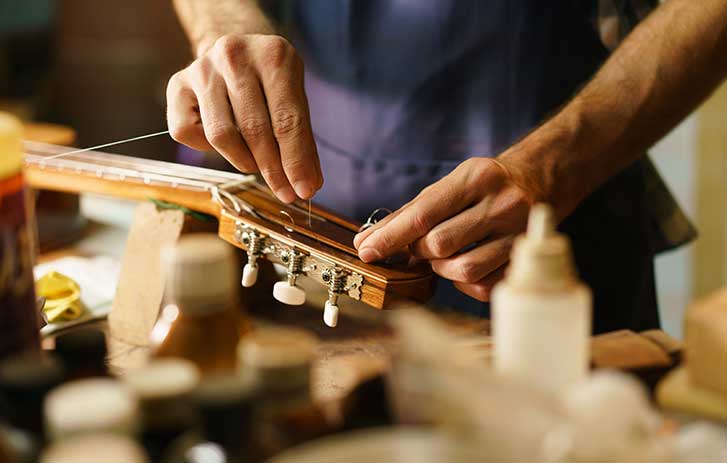 Hands working on a guitar