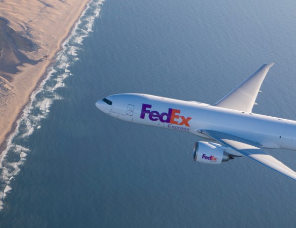 FedEx plane over water flying toward land