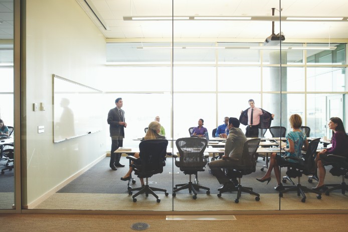 Coworkers gather around a conference room table.