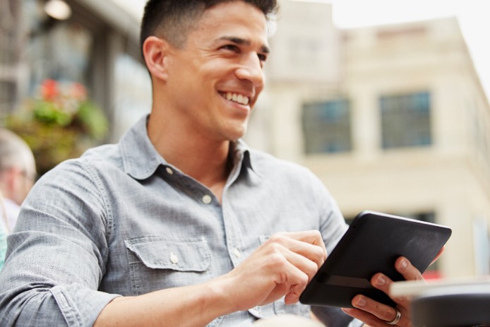man sitting outdoors working on device