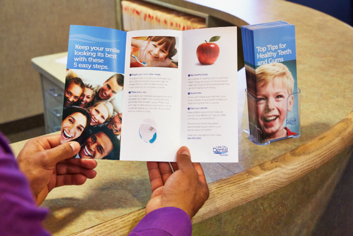 Person looking over a brochure A customer opening a brochure and reading it