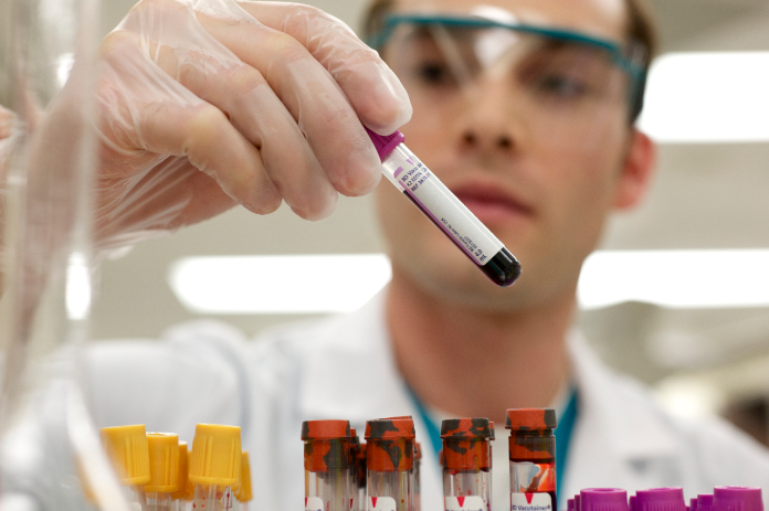 Lab tech looking at samples in vials