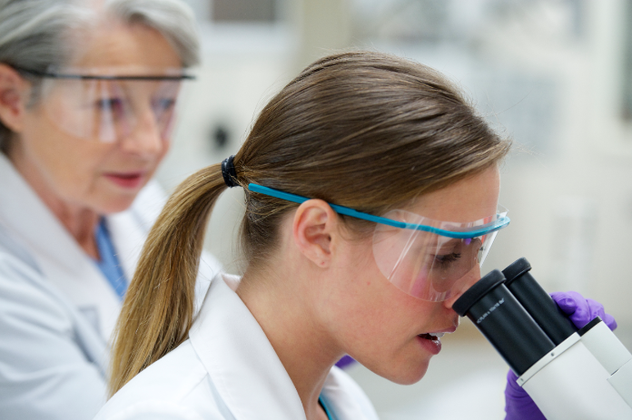 Lab tech looking into microscope