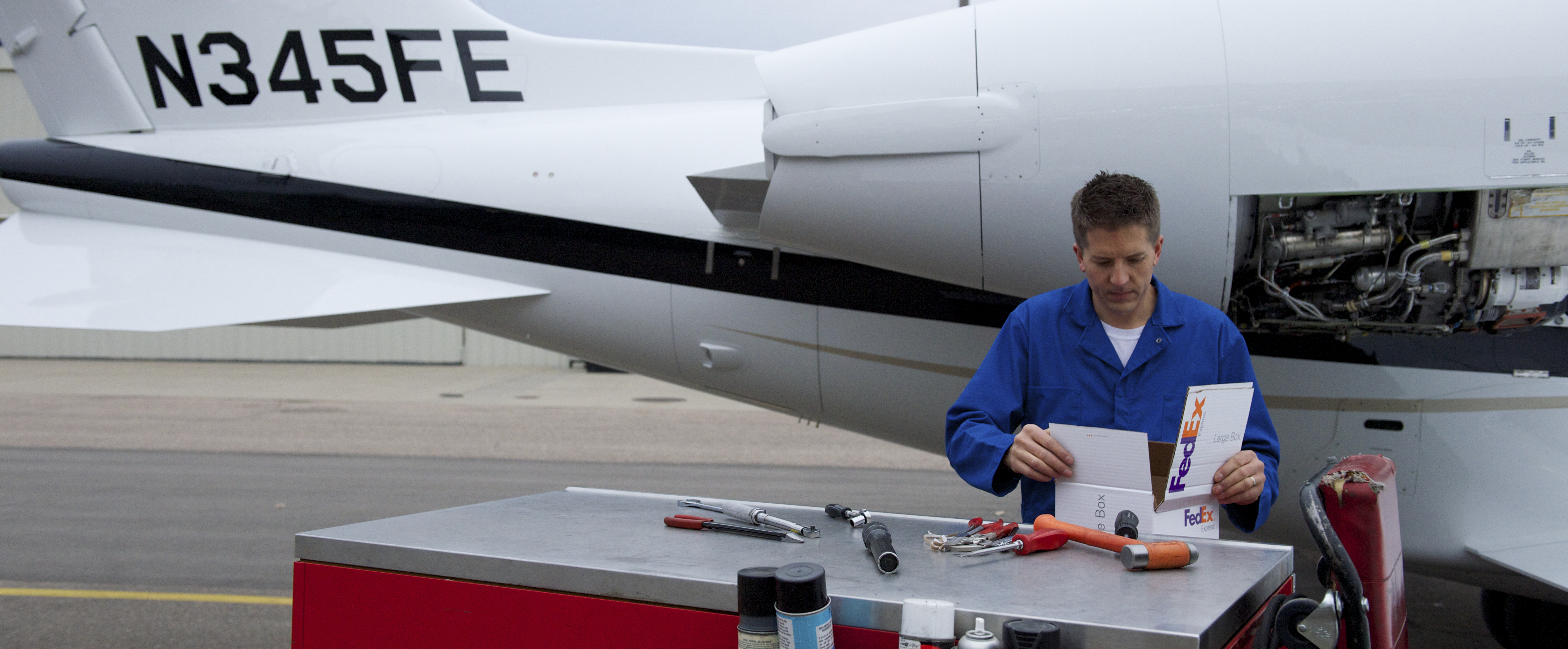 man opening fedex package for aerospace