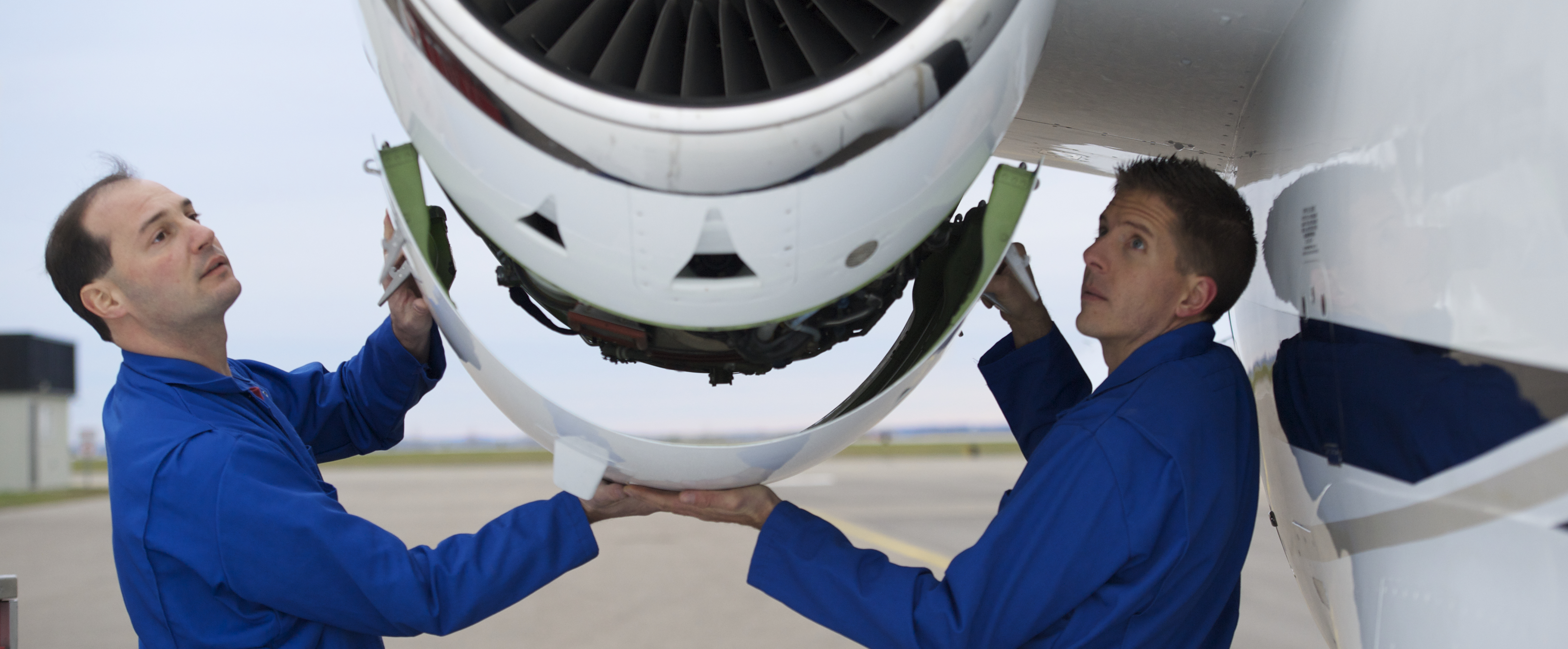 two employees working on airplane engine
