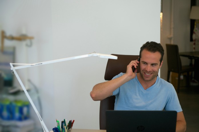 man talking on phone in home office