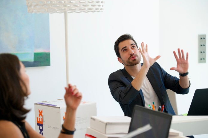 A man and woman talking at desks