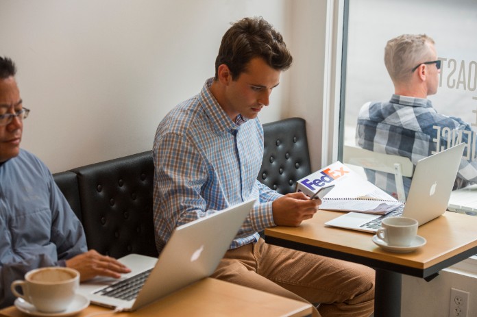Man looking at phone in coffee shop