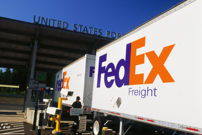 A FedEx Freight double-trailer goes through a border checkpoint into the U.S.