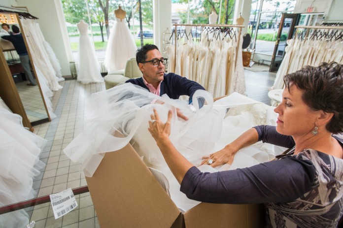 Boutique employees packing bridal gown into large box