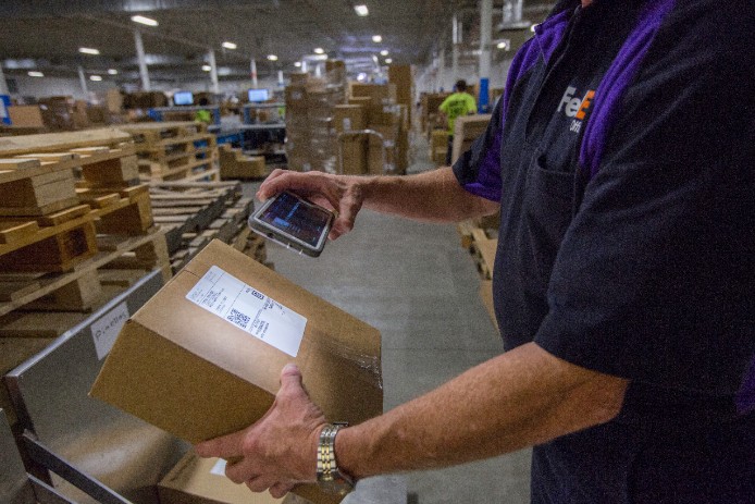 Man scanning a FedEx box Man scanning a FedEx box