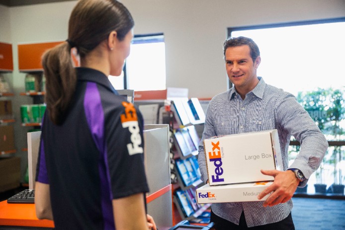 Man bringing packages into a FedEx retail location