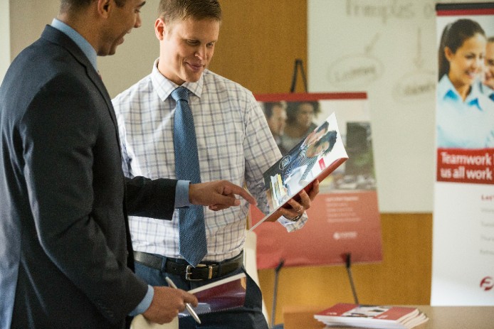 Employee reviewing a presentation booklet Employee reviewing a presentation booklet