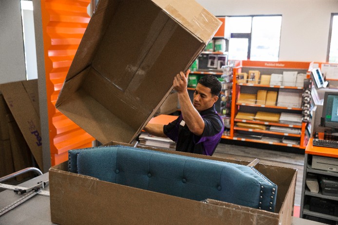 FedEx employee putting package together