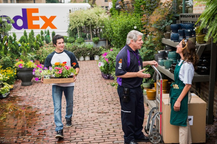 A FedEx courier delivering a box to a garden supply store