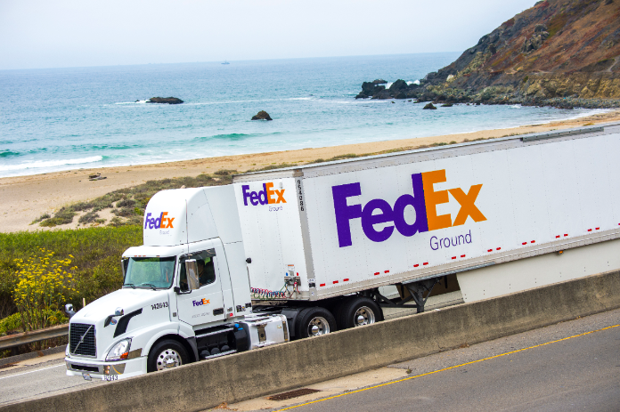FedEx Ground truck driving on highway alongside the beach
