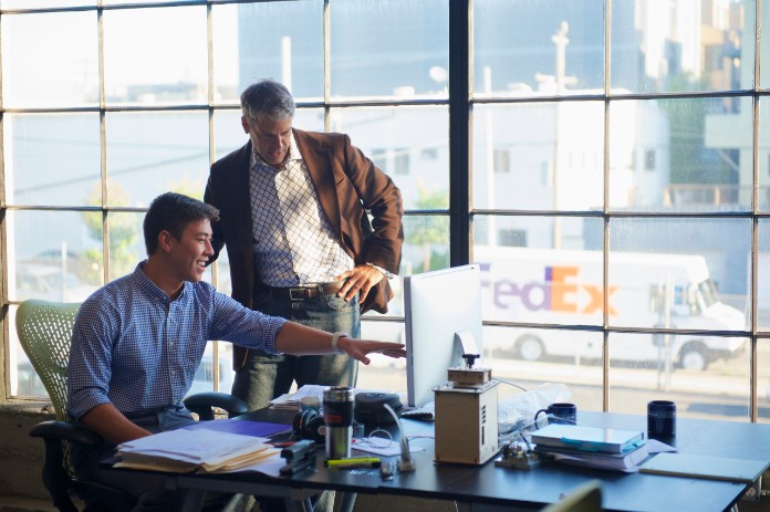 Two professionals looking at a desktop
