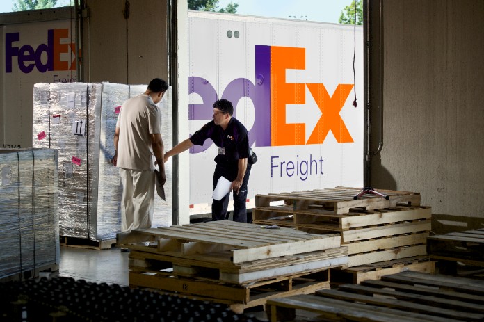 FedEx employee gathering freight shipments on pallets