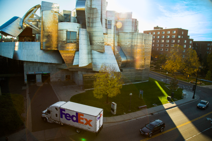 FedEx truck in city driving into receiving dock.
