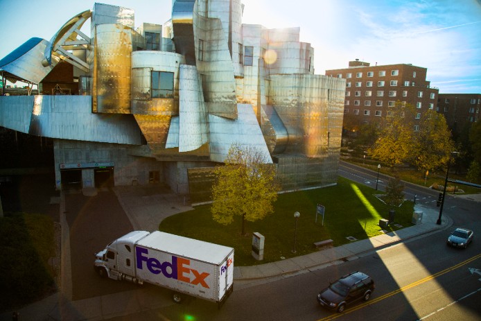 FedEx truck in city driving into receiving dock.