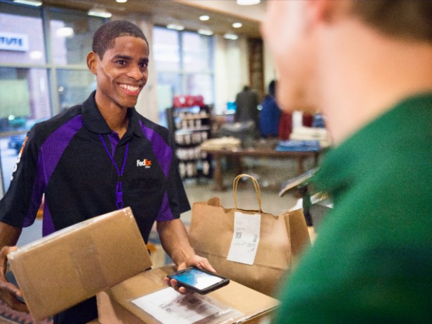 A courier scans and affixes return labels onto packages