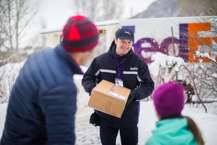 Family getting package from FedEx employee