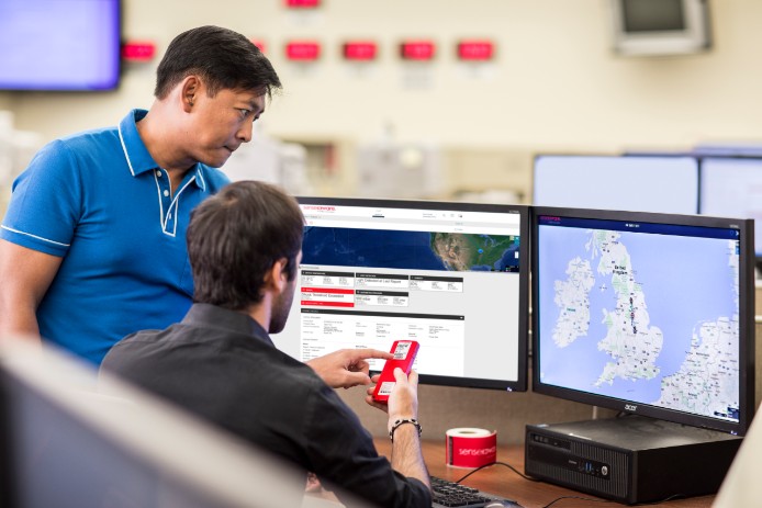 Two men looking at computer screens and talking