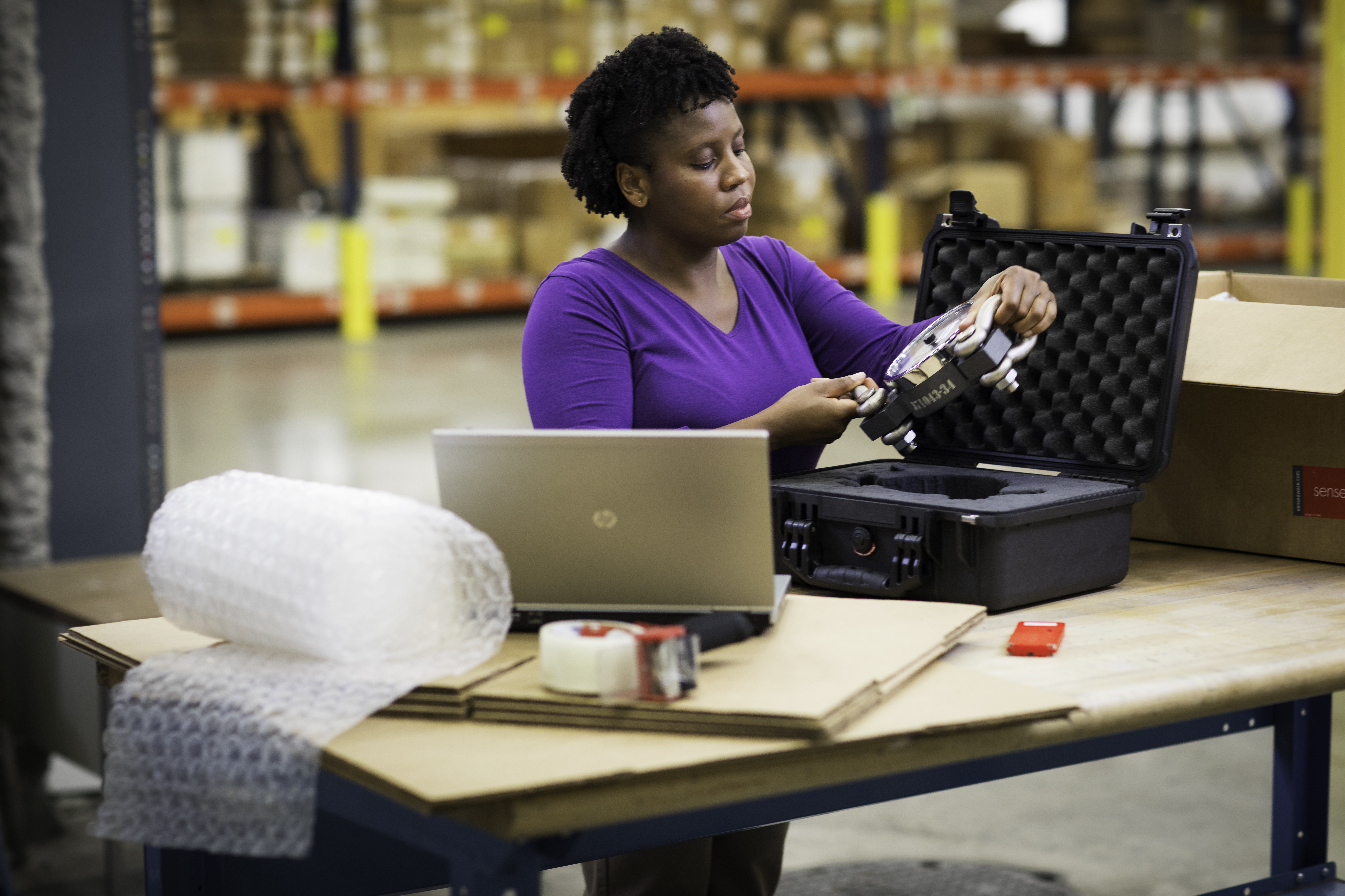 Woman packaging an item in a warehouse