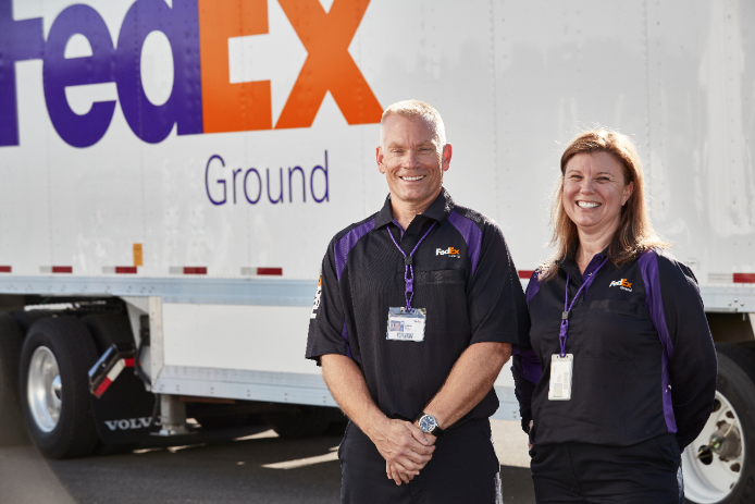 FedEx Ground employees get ready to make a delivery.