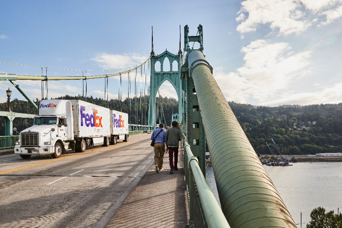A FedEx Freight double-trailer crosses the gothic St. Johns bridge in Portland, OR.
