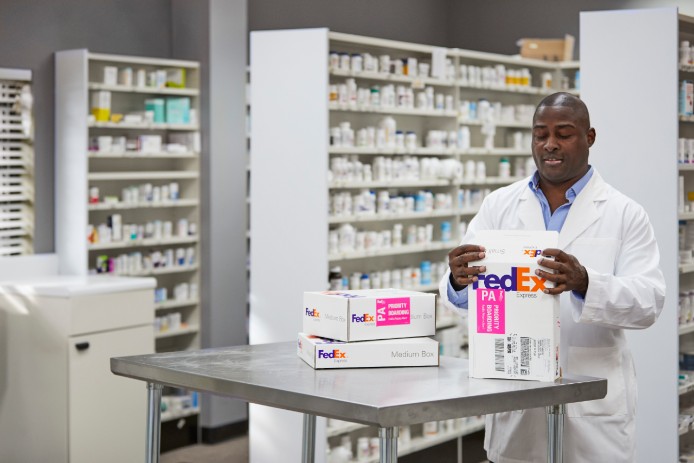 A pharmacist prepares a FedEx Priority Alert shipment