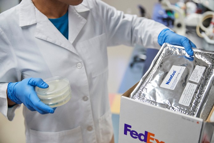 lap technician packing a FedEx box with a cooling pack