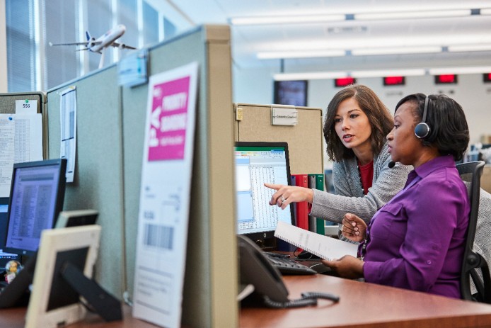 Two women working on a computer together.