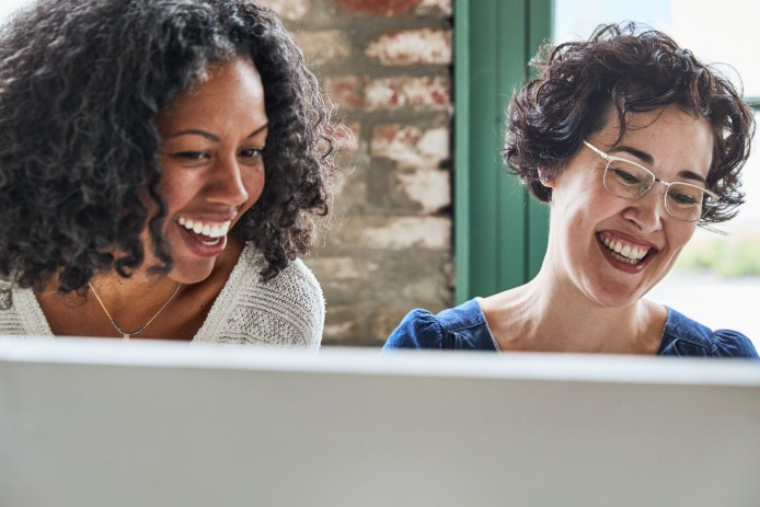 two women looking at a desktop computer