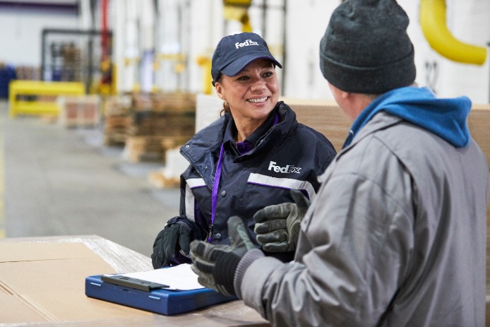 Courier talks to man in warehouse