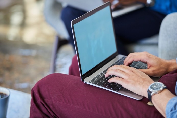 Man typing on laptop in his lap