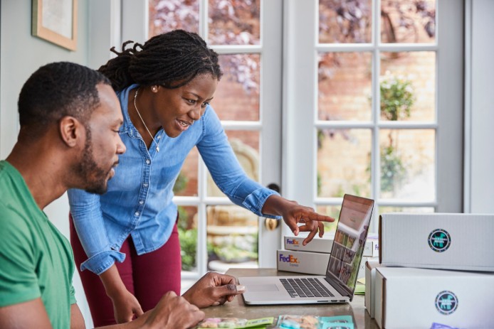 woman and man looking at fedex.ca on computer