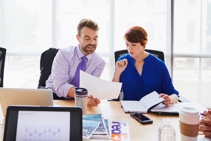 Two people in.a meeting looking at a piece of paper