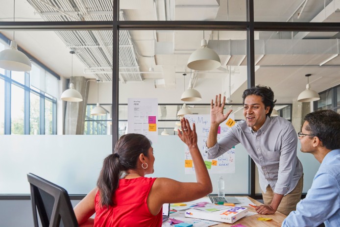Team members giving each other High Fives in a meeting